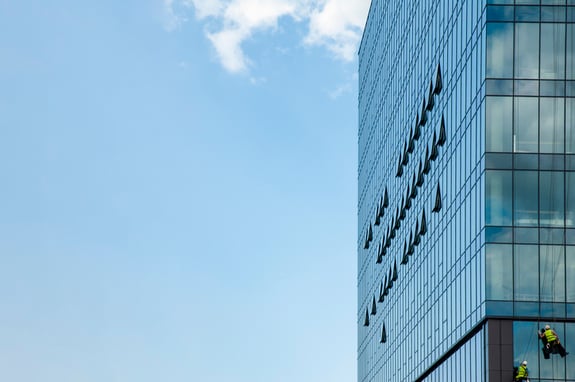 Blå himmel og siden av et stort glassbygg